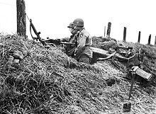 Soldiers of the 101st U.S. Airborne Division behind cover in Normandy