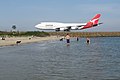 Qantas jet on taxiway with aircraft viewing area and Botany Bay beach in foreground
