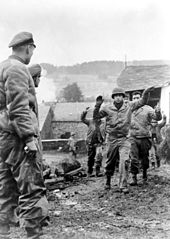 Amerikanische Soldaten des 3. Bataillons der U.S. 119th Infantry werden am 19. Dezember 1944 von Mitgliedern der Kampfgruppe Peiper in Stoumont, Belgien, gefangen genommen.