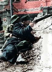 Soldat fra Bataljon Kiliński sigter med sin riffel mod den tyskbesatte PAST-bygning, 20. august 1944