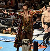 Okada haciendo su característica pose durante su etapa como Campeón de Peso Pesado IWGP en julio de 2013  