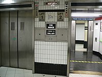 Kaksi hissiä Lontoon metroaseman alemmalla tasolla. Nuolet osoittavat kunkin hissin sijainnin ja kulkusuunnan. Oikeanpuoleinen hissi valmistautuu nousemaan ylös, ja vasemmanpuoleinen hissi laskeutuu ylimmästä kerroksesta.  