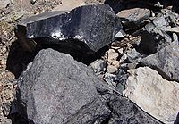 Tegen de klok in van boven: obsidiaan, puimsteen en rhyoliet (lichte kleur)  
