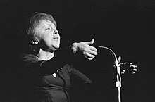 Édith Piaf singt vor einem Mikrofon (1962).