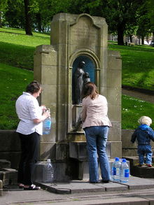 Gente llenando botellas de agua en el Pozo de Santa Ana