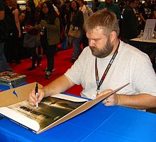 Tvůrce seriálu Walking Dead Robert Kirkman podepisuje plakát k seriálu na newyorském Comic Conu 2011.
