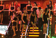 Prostituees voor een bar, in Thailand: : Zoals slaven op een veilingblok die wachten om geselecteerd te worden, moeten slachtoffers van mensenhandel doen wat hen gezegd wordt, of ze worden geslagen.  