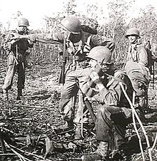 Noemfoor, Nizozemská Nová Guinea, červenec 1944. Americký voják (v popředí) používá během bitvy vysílačku. (Fotograf: Allan F. Anderson)  