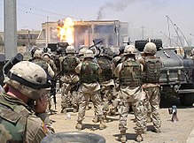 Soldater fra 101st Airborne Division og U.S. Special Operations (Task Force 20) ser et TOW-missil ramme siden af et hus beboet af Uday og Qusay Hussein i Mosul, den 22. juli 2003.  