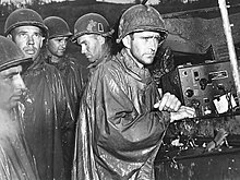 77. Tümen'e bağlı Amerikan askerleri 8 Mayıs 1945'te Avrupa'da Zafer Günü'ne ilişkin radyo haberlerini kayıtsızca dinliyor.