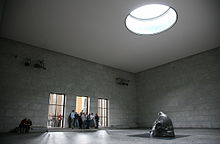 Notranjost Neue Wache s skulpturo Käthe Kollwitz Mati z mrtvim sinom in okulusom, ki skulpturo izpostavlja elementom.
