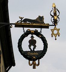 Das Schild über dem Eingang zeigt den Mann mit baumelnden Armen