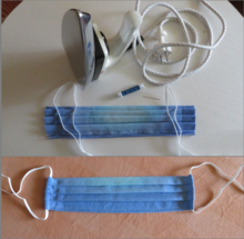Hand-sewn makeshift mouth-nose mask made of cotton with folds ironed in before sewing, can be disinfected by ironing