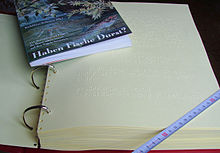 Libro en braille y el mismo libro en letras comunes  