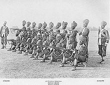 Indijas sikhu karavīru grupa pozē, lai saņemtu salūtšāvienu pavēli. ~1895