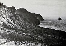 Ostküste von Gough Island mit der 115 m (377 ft) hohen Pinguin-Insel, die 0,8 km (0,5 mi) vom Punkt entfernt liegt