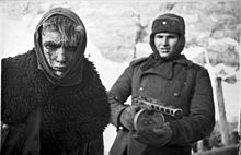 În această fotografie de propagandă, un soldat al Armatei Roșii duce în captivitate un soldat german.  