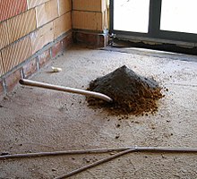 A pile of sand (brown) and cement (grey) prepared for mixing.