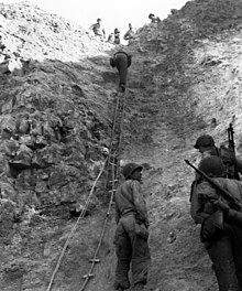 Rangers climb up the cliff ...