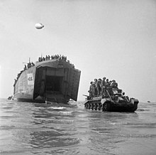 Cromwell tank with soldiers on the way to Gold Beach