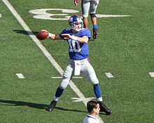 Eli Manning, QB de los New York Giants, lanzando en los calentamientos previos al partido en 2009. Obsérvese cómo sostiene el balón y la posición de sus piernas.
