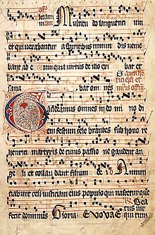 Esta es una página de un libro cuyo título es Graduale Aboense. Aquí puedes ver una canción sobre San Enrique, un hombre santo de Finlandia. Las marcas negras, que están encima de las palabras, muestran el aspecto de la música. La canción comienza en la gran letra G del centro de la página.  