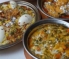 Hyderabadi biryani podawane z daniami kuchni indyjskiej.