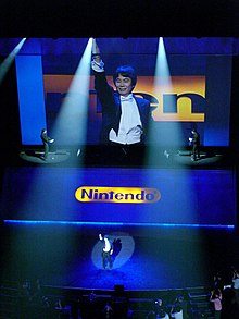 Miyamoto pitelee Wii-kaukosäädintä E3 2006 -tapahtumassa.  