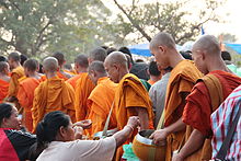 Buddhalaismunkit keräävät almuja.  