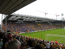 Tribuna Jarrold - hostující fanoušci v modré barvě sedí v bloku vlevo od tribuny.