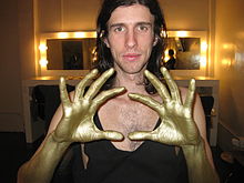 "3OH!3" logotipas su rankos gestu, dėl kurio bylinėjosi profesionalus imtynininkas Diamondas Dallasas Page'as.