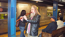En indiansk fløjtespiller spiller for donationer på en togstation i New York City.  