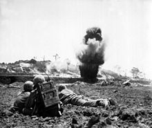 Bir 6. Tümen Deniz imha ekibi patlayıcıların infilak ederek bir Japon mağarasını yok etmesini izliyor, Mayıs 1945.