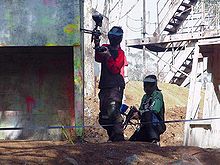 Giocatori di paintball che si nascondono dietro un rifugio