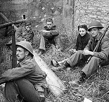 Canadian soldiers guard a French woman and German prisoners near Caen, July 19.