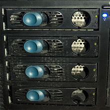 Primo piano di 4 dischi che compongono un array RAID, integrato in un sistema desktop. Le chiusure blu permettono lo scambio dei dischi mentre il sistema continua a funzionare.
