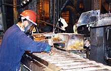 Un lavoratore sta riciclando il piombo delle batterie.