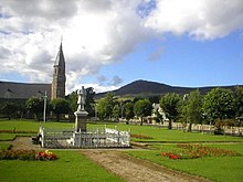 Kylän viheriö ja sotamuistomerkki, Rhynie Kirk viheriön takana, ja Tap o' Noth kaukana.