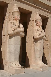 Estatuas osirianas de Hatshepsut en su tumba, una en cada pilar. Obsérvese el sudario de momificación que encierra la parte inferior del cuerpo y las piernas, así como el báculo y el mayal asociados a Osiris-Deir el-Bahri
