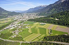 Aerial view of the city of Bludenz in northwestern direction; in the foreground the district Brunnenfeld and the S16, in the middle ground the Arlbergbahn is visible running along the edge of the forest.
