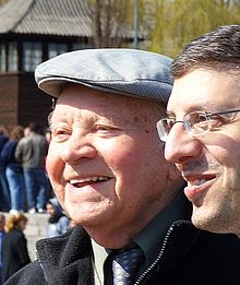 Henryk Mandelbaum a tlumočník hovoří na místě krematorií v Birkenau. Byl členem táborového Sonderkommanda.