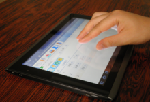 O persoană care utilizează ecranul tactil al unui computer tabletă.