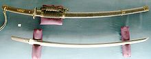 Tachi smedet af Bishu Osafune Sukesada, 12. år af Eishō-æraen, en dag i februar (1515, Muromachi). Saya i aogai-nashiji lak, gyldne dekorationer. Montering fra 1907, seneste polering i 1987.