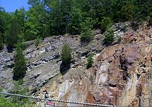 Üstteki açılı gri dolomit tabakası yaklaşık 500 milyon yaşındadır. Dolomitin üzerine oturduğu kırmızımsı riyolit yaklaşık 1,5 milyar yaşındadır. Bu resimde bir milyar yıllık jeolojik tarih eksik. Missouri Ozarks.