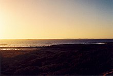 Rayleigh scattering causes the blue hue of the sky during the day and the red hue of the sun when it sets or rises.