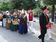 In traditional costumes with large castanets (Castanyoles)