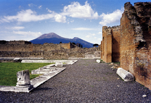 O Monte Vesúvio, visto das ruínas de Pompéia, que foi destruído quando irrompeu em 79 AD. O cone ativo é o pico alto do lado esquerdo. O menor do lado direito é parte da parede da Somma Caldera.