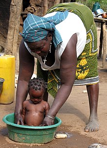 Badning af en baby i Mozambique.
