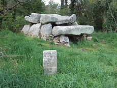 Dolmen Er-Roc'h-Feutet. Nápis vedle každého stojícího kamenného útvaru hlásá, že jeho vlastníkem je stát Francie.