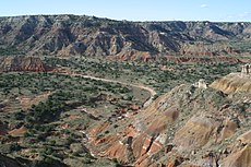 Palo-Duro-Schlucht. Die roten, tiefer gelegenen Hänge des Canyons sind vom Alter her permisch. Diese Schichten wurden in einer flachen Meeresumgebung abgelagert, die sich mit trockenen Wattflächen abwechselte.